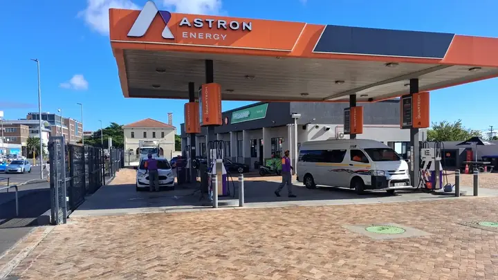 A minibus taxi and a car at the pumps of a petrol station in Observatory, Cape Town